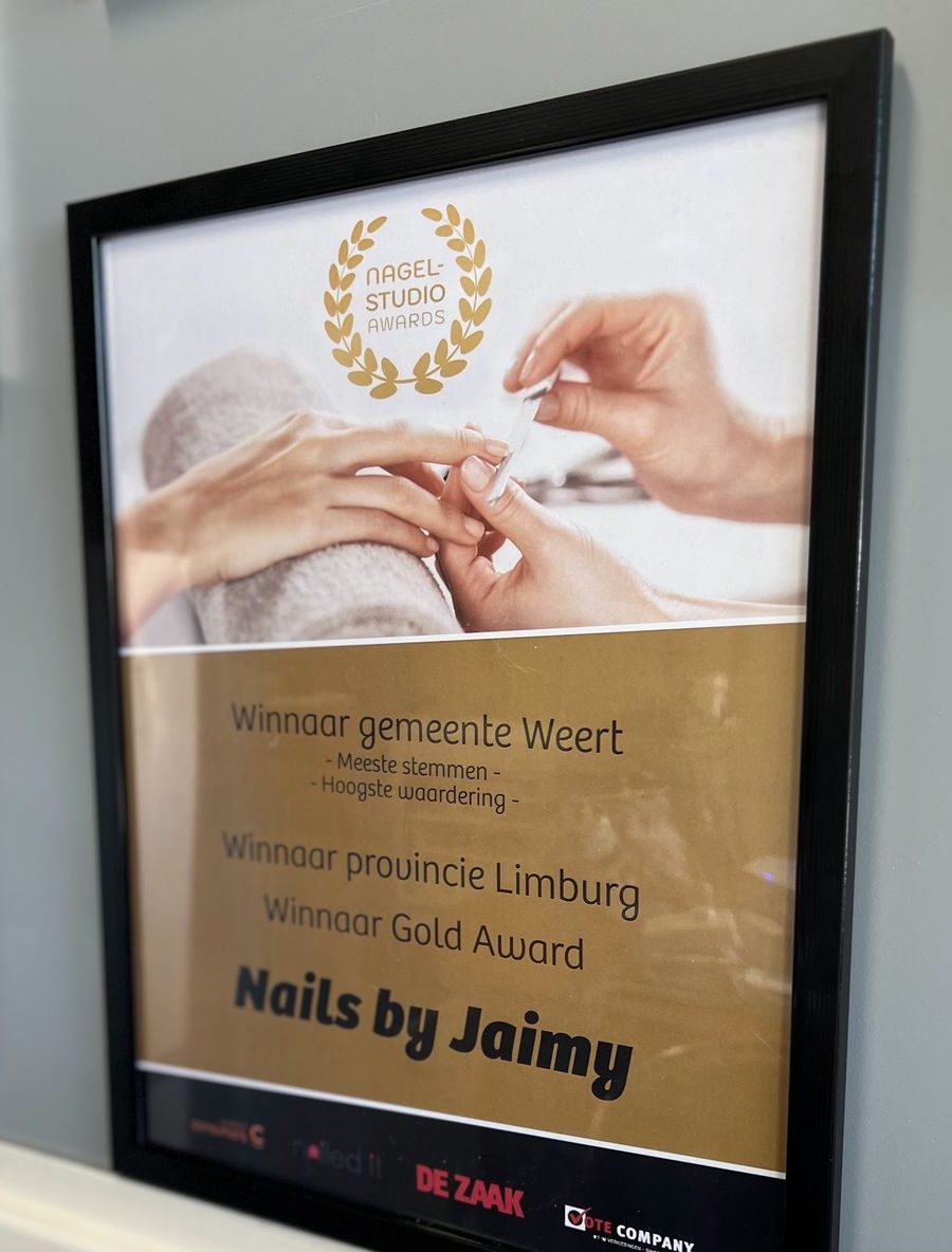 Het ingelijste certificaat van de Nagelstudio Awards aan de muur van de salon